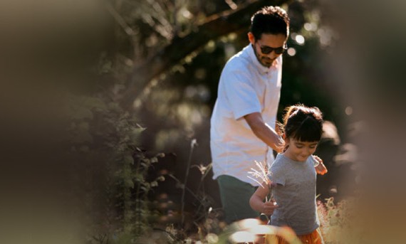 A young boy holding hand of his father